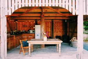 a wooden pavilion with a table and a kitchen at Nyland View The Paddocks Glamping in Draycott