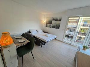 una habitación con una cama, una mesa y un sofá en Calme et ensoleillé balcon quartier Port Nice, en Niza