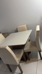 una mesa blanca y sillas junto a una pared en Casa do Aconchego Castanhal, en Castanhal