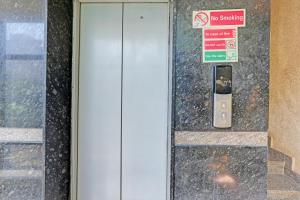 a door to a building with a no smoking sign at Hotel O PMR Hotel in Bengaluru