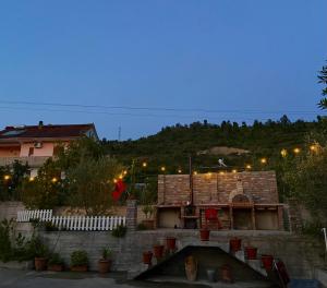 a house with a fire pit in a yard at night at Guesthouse Hoxholli in Gramsh +9 photos