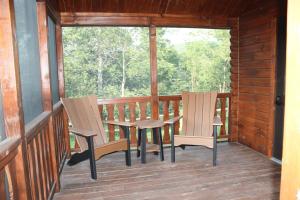 two chairs and a table on the porch of a cabin at Tiny Cabin #3 by Windham NY Escape 'Forest View' in Hensonville