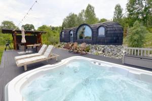 einen Whirlpool auf einer Terrasse mit einem Pavillon in der Unterkunft Friday Inn Igloo - Intimitate, Jacuzzi, Natura, Priveliste & Iaz - Escapadă romantică premium la o oră de Bucuresti - Eco Friendly Micro-Resort in Comarnic