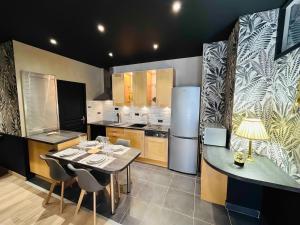 a kitchen with a table and chairs and a refrigerator at LEtape Prestige Hyper-Centre Calme in Reims