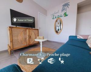 a bedroom with a bed and a tv and a table at Le léza - Terrasse et plage à 1 min in Les Trois-Îlets +14 photos
