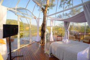 ein Schlafzimmer mit einem Bett und einem großen Fenster in der Unterkunft Villa das Cabanas – Viva o Luxo da Natureza em Piri in Pirenópolis