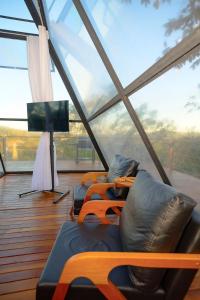 ein Zimmer mit vier Stühlen und einem Fernseher in einem Zimmer in der Unterkunft Villa das Cabanas – Viva o Luxo da Natureza em Piri in Pirenópolis + 50 Fotos