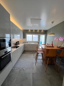 een keuken met een tafel en een eetkamer bij Toi et Moi-Guests speek for us! in Ponta Delgada