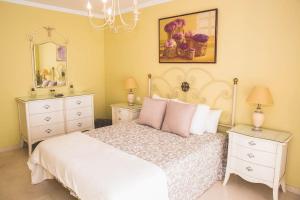 1 dormitorio con 1 cama blanca, 2 mesitas de noche y espejo en Espectacular piso en primera línea de playa, en Estepona