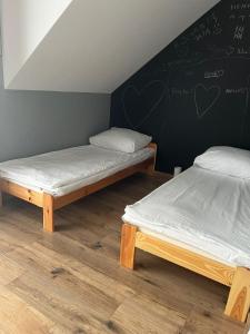 two beds in a room with a wall with hearts on it at Domki i dom w sadzie Stegna z podgrzewanym basenem - prywatne jacuzzi przy domu in Stegna +27 photos