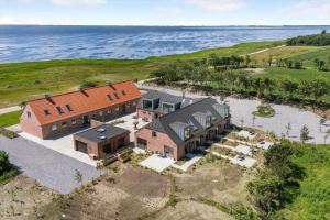 an aerial view of a large house with the ocean behind it at 1171-Ringkobing-Jagtvej-34-C-lejl-2 in Ringkøbing
