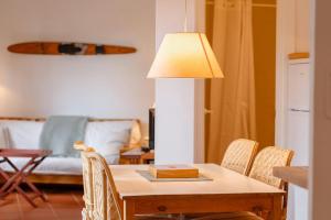 a table with a lamp and chairs in a living room at T5 · Cozy Retreat 50m to Beach Garden Escape in Tamariu +23 photos