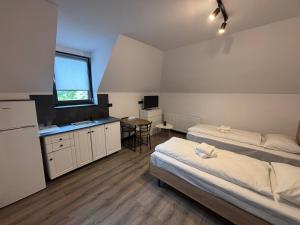 a room with two beds and a table and a window at La Conac Sibiu in Sibiu