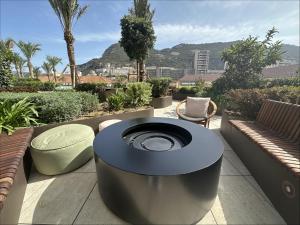 a circular object sitting on a patio with two benches at New! Luxury Central Complex with Pool Access & Sleeps 4 Ppl in Gibraltar