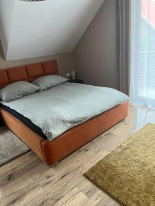 a bedroom with a bed with an orange headboard at Domki i dom w sadzie Stegna z podgrzewanym basenem - prywatne jacuzzi przy domu in Stegna