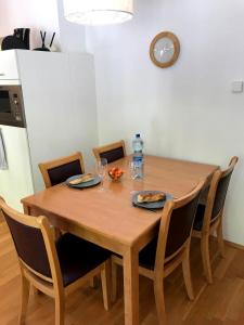 ein Esstisch aus Holz mit Stühlen und einer Uhr in der Unterkunft Manuela 12 by SMR Rauris Apartments - inc Spa and near Gondola in Rauris