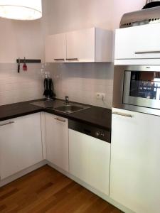 eine weiße Küche mit Spüle und Mikrowelle in der Unterkunft Manuela 12 by SMR Rauris Apartments - inc Spa and near Gondola in Rauris