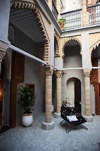 um pátio com duas cadeiras num edifício em L'Alcazar em Rabat