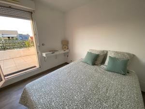 シルティカイムにあるLa Résidence St Arnould, À 10 min du centre de Strasbourgのベッドと大きな窓のある寝室