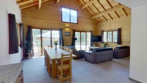 a kitchen and living room with a table and chairs at CASA-Grand Laus: Duplex familial sauna et jacuzzi in Aiguilles