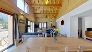 a dining room and living room with a table and chairs at CASA-Grand Laus: Duplex familial sauna et jacuzzi in Aiguilles