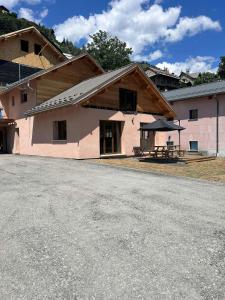a building with a picnic table in front of it at CASA-Grand Laus: Duplex familial sauna et jacuzzi in Aiguilles