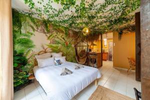 two cats laying on a bed in a room with plants at L'aventurier - Jacuzzi Lounge & Massage in Vierzon