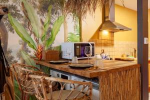 a kitchen with a island with a computer on it at L'aventurier - Jacuzzi Lounge & Massage in Vierzon +12 photos