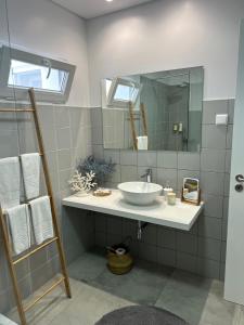 een badkamer met een wastafel en een spiegel bij Toi et Moi-Guests speek for us! in Ponta Delgada