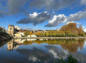 a view of a river with buildings in the background at Latelier DArtistes : expérience créative in Vierzon