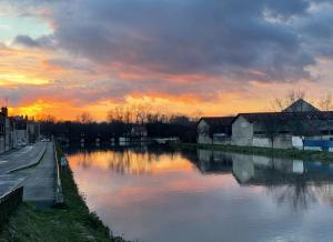 a view of a river with a sunset in the background at Latelier DArtistes : expérience créative in Vierzon +8 photos