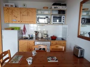 a kitchen with a wooden table and a kitchen with a counter top at Chalet Chamrousse – Balcon avec vue Proche Pistes in Chamrousse +13 photos