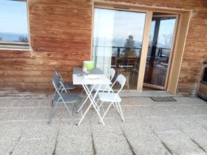 a table and chairs on the patio of a house at Chalet Chamrousse – Balcon avec vue Proche Pistes in Chamrousse