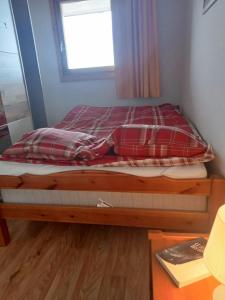 a small bed in a room with a window at Chalet Chamrousse – Balcon avec vue Proche Pistes in Chamrousse