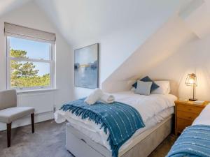 Un dormitorio con una cama y una silla y una ventana. en 3 Bed in Woolacombe 87573, en Mortehoe