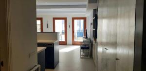 a kitchen with a counter and a hallway with windows at Calella Port Bo - Sea Sand Sun in Calella de Palafrugell