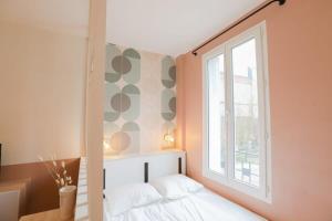 a bedroom with a white bed and a window at Stadium Pink Loft 5min Rer near Paris in Aubervilliers +16 photos
