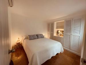 a bedroom with a white bed and a window at Tamariu Platja · Penthouse on Passeig del Mar. in Tamariu +50 photos