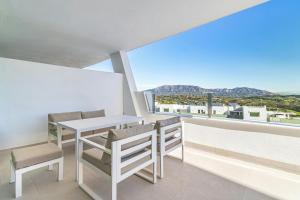 ein Balkon mit Tisch und Stühlen und Aussicht in der Unterkunft Bello piso con vistas espectaculares y un spa in Sitio de Calahonda