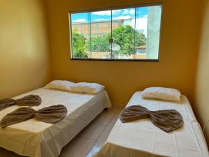zwei Betten in einem Zimmer mit Fenster in der Unterkunft Espaço Dona Deja in Bom Jesus da Lapa