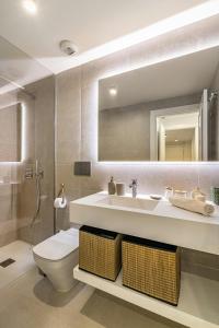 a bathroom with a sink and a toilet and a mirror at Bonito piso con Spa y vistas a la montaña in Sitio de Calahonda