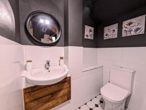 a bathroom with a sink and a toilet and a mirror at Villa Vasil Mertiri in Himare