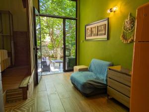 a green living room with a couch and a sliding glass door at Villa Vasil Mertiri in Himare