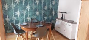 a dining room table and chairs with a green and white wallpaper at Ferienhaus im Mansfelder Land in Wimmelburg