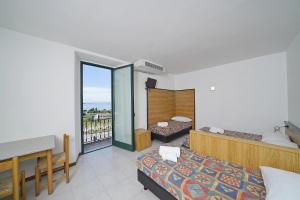 a hotel room with two beds and a balcony at Hotel La Pergola in Moniga +102 photos