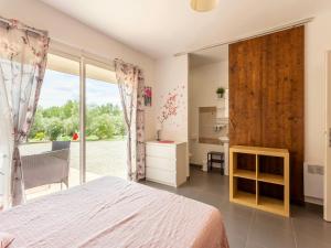a bedroom with a bed and a large window at Casa-des Oliviers maison vacances avec piscine in Montmeyan