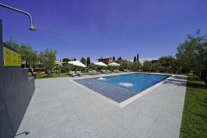 a swimming pool in a yard with umbrellas at Hotel La Pergola in Moniga
