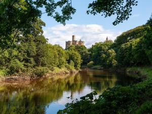 une rivière avec un château en arrière-plan dans l'établissement 2 Bed in Warkworth CN004, à Warkworth