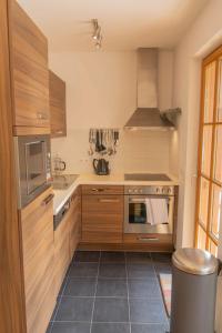 ラウリスにあるMartina 6 by SMR Rauris Apartments - inc Spa and near Gondolaの木製のキャビネットとコンロ付きオーブンを備えたキッチン