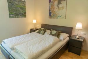 ラウリスにあるMartina 6 by SMR Rauris Apartments - inc Spa and near Gondolaのベッド1台(ナイトスタンド2台、ランプ2つ付)